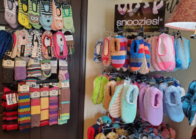 Snoozies on a rack at Olde Homestead, pairs of cute socks