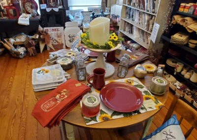 table with plates, candles, and table linens on shelves at Old Homestead